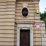 ...la cui simmetria � per� �spezzata� da un piccolo corpo di fabbrica leggermente rientrante rispetto al resto. Qui � presente anche un accesso secondario chiuso in una cornice decorata, sovrastata da un�apertura ovale con inferriata a volute...